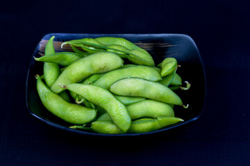 Japanese edamame in a black ceramic dish