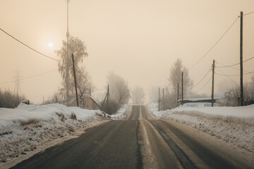 winding road gets lost in fog on a frosty winter morning