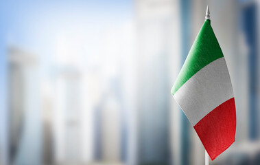 A small flag of Italy on the background of a blurred background