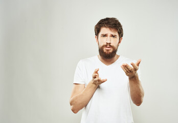 Guy on a white background gestures with his hands in a T-shirt cropped view