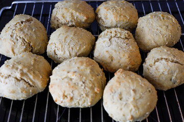 Homemade bread rolls on an oven rack.