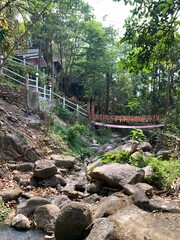 Wooden foot bridge across small dried river in the park.
