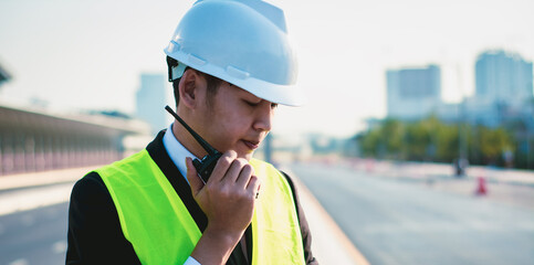 Asian manager engineer with hardhat,work outside industry,use digital tablet,radio communication control,with walkie talkie,work survey building construction factory site,business working and industry