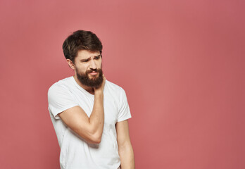 Man on a pink background in a white t-shirt emotions model cropped view