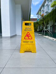 A wet floor sign placed next to the pool. Reads "Caution wet floor"