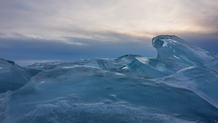Ice hummocks against the sunset sky. Thick layers of transparent turquoise ice of bizarre shape....