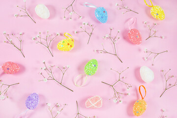 Colorful Easter Eggs with white gypsophila on pink background.