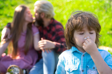 Happy kiss family doing picnic in garden or park. Young smiling family leisure together sunny day.