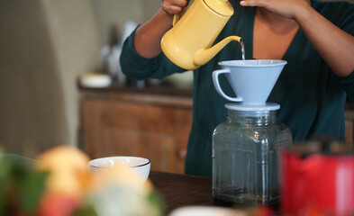 barista preparing brewing coffee with coffee maker and drip kettle.