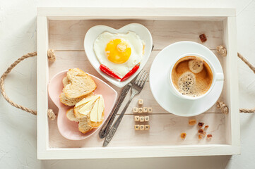 Mother's Day. Breakfast for mom. On the tray there is a cup of coffee, two plates of scrambled eggs...