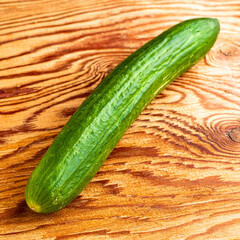 green cucumber on the wooden surface of the table