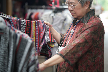 old senior elder woman choosing clothes at store shop