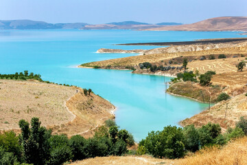 Fototapeta na wymiar Ataturk Dam (GAP) near Samsat in the Adiyaman Province of eastern Turkey. On the right are paddocks of harvested grain crops