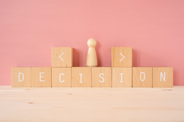 人生の選択｜「DECISION」と書かれた積み木ブロックと人型の人形