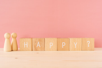 幸せとは？「HAPPY?」と書かれた積み木と人型のオブジェ