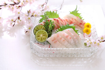 Sea bream sashimi on glass plate with beautiful cherry...