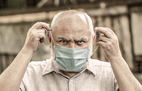 Concept danger of coronavirus for the elderly. Portrait old man in a surgical bandage, coronavirus, medical mask