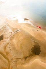 Aerial view of paraglider flying over an island.