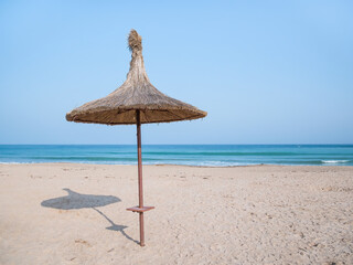 Summer landscape with straw umbrellas on the beach in Mangalia or Mamaia. Beach at the Black Sea in Romania.