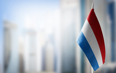 A small flag of Netherlands on the background of a blurred background