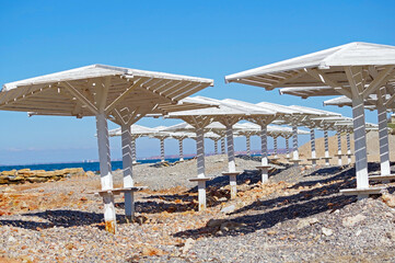 Sea beach with sand and row of wooden umbrellas