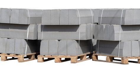 The pallet with a stack of concrete curbstone on white