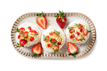 Perfect mini Pavlova cake with whipped mascarpone cream and fresh strawberry slices, sprinkled with crushed pistachios. isolated on white background. top view