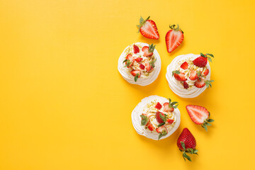 Perfect Pavlova with whipped mascarpone cream and fresh strawberry slices, sprinkled with crushed...