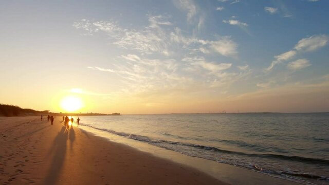 View of the sunset at the beach at Bet Dwarka in Gujarat, India. Summer holiday beach background. Silhouette of people walking on the beach. Travel and Holiday Concept, Summer holiday Relaxation 