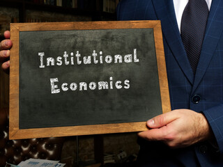Financial concept about Institutional Economics with sign on the black chalkboard.