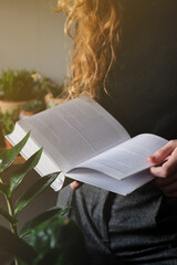 Woman reading a book, girl holds white book while reading at home. Reading mock up , close up details. 