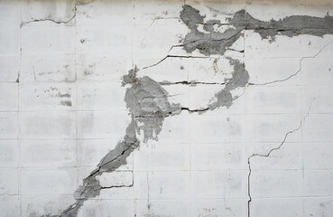 A brick wall with many cracks fixing by rough cement.  It shows construction problem and low...