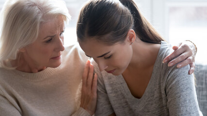 Loving old Caucasian mom hug comfort unhappy stressed millennial grownup daughter feeling sad...