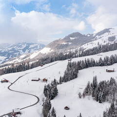 Fototapeta na wymiar Holidays in winter in Europe. Switzerland. Canton of Schwyz. Chalet in snow drifts.