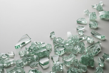 Fragments of broken glass mint color on a white background. Place for text.