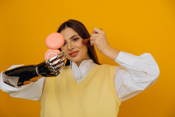 Attractive long haired woman with stylish bionic arm applies makeup looking in pocket mirror on...