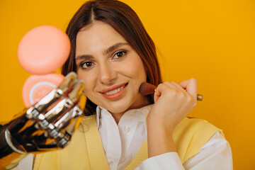 Attractive long haired woman with stylish bionic arm applies makeup looking in pocket mirror on...