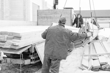 Fototapeta na wymiar Workers offloading sawn timber