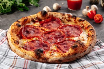 Baked appetizing ham pizza on the decorated grey background