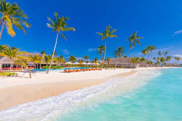 Luxurious beach resort with swimming pool and beach chairs or loungers under umbrellas with palm trees and blue sky. Summer island travel and vacation destination. Relax lifestyle, leisure carefree