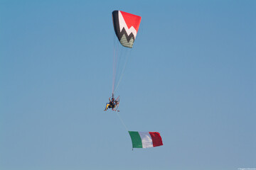 Flying paraglyder with italian flag