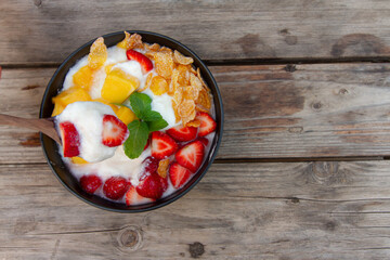 yogurt mixed fruit Strawberries mango conflex mint on wooden table top view