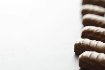 Chocolate bars on a black background in backlight. Chocolate with filling. Sweet sweets for snack and tea.
