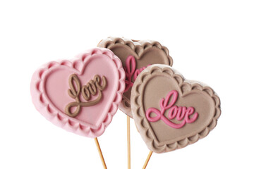 Heart shaped lollipops made of chocolate on white background
