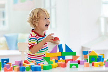 Kids toys. Child building tower of toy blocks.
