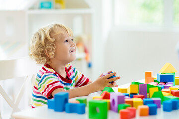 Kids toys. Child building tower of toy blocks.