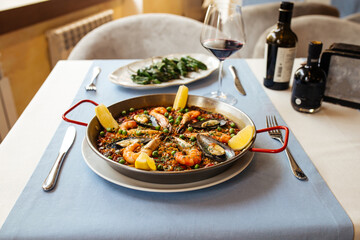Side view on spanish seafood paella pan with mussels and shrimp