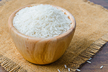 Organic Thai Jasmine rice grain in wooden bowl.