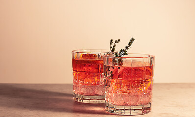 Pink gin cocktail with red blood orange and ice. An alcoholic, refreshing drink. - obrazy, fototapety, plakaty