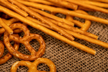 Salted breadsticks and salted pretzels scattered on the table.